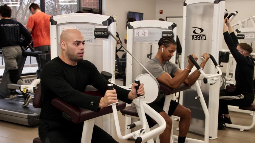 students working out on machines in fitness center